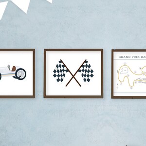May include: Three framed prints with a racing theme. The first print shows a white vintage race car. The second print shows two crossed checkered flags. The third print shows a black and white illustration of a race track with the text "Grand Prix Race Course".