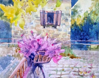 May include: Watercolor painting of a bicycle with a basket overflowing with pink flowers. The bicycle is parked on a brick path, with a stone building and foliage in the background. The artwork is signed in the lower right corner.