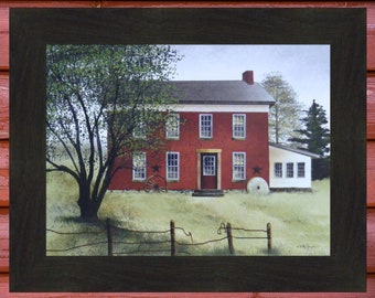 May include: Framed print of a red brick house with white trim, a red door, and a chimney. A large tree is on the left, and a wooden fence is in the foreground. The artwork is in a dark brown frame.