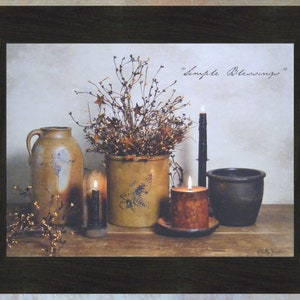 May include: A framed print of a still life featuring a rustic brown and blue pitcher, a brown and white ceramic pot with a floral arrangement, two lit candles, and a black ceramic pot. The text "Simple Blessings" is written in cursive in the upper right corner of the print.