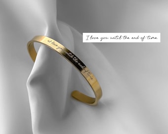 May include: A gold-toned bangle bracelet with the inscription "I love you until the end of time" engraved on the band.