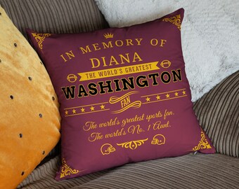 May include: A maroon throw pillow with gold text that reads "In Memory of Diana The World's Greatest Washington Fan. The world's greatest sports fan. The world's No. 1 Aunt."