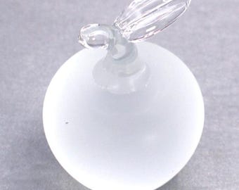 May include: A frosted glass apple figurine with a clear, leaf-shaped stem. The apple is a soft white color and has a smooth, rounded shape. The stem is delicate and adds a touch of detail to the overall design.
