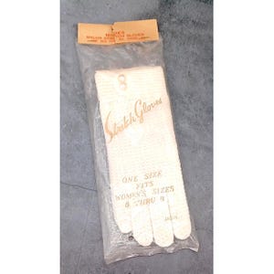 May include: A pair of off-white nylon stretch gloves in a clear plastic package. The packaging features the text "Stretch Gloves," "ONE SIZE FITS WOMEN'S SIZES 6 THRU 8," "JAPAN," and "NYLON STRETCH GLOVES ONE SIZE FITS ALL HANDS" printed on the top label.