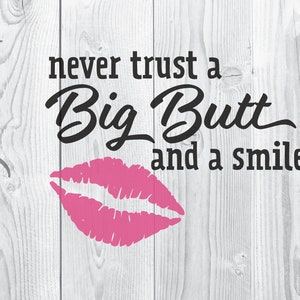 May include: A pink lipstick print with the text "never trust a Big Butt and a smile" on a white wood background.