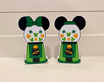 May include: Two green and white gumball machine themed decorations with Mickey Mouse ears and shamrocks. The decorations are perfect for a St. Patrick's Day party.