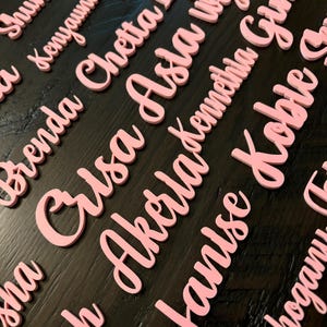 May include: Pink foam letters spelling out the names Shuntae, Kenyauna Mist, Brenda Chetta Lyn, Crusa Asia Wylon,  Akerla Kennthia Gina, Janise Koble, and Mahogany.