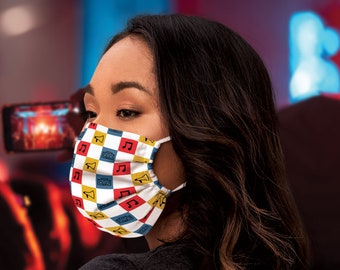 Op de afbeelding: Een persoon draagt ​​een mondkapje met een geruit patroon en muzieknoten. Het masker is rood, geel, blauw en wit.