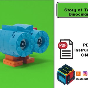 May include: A blue and red Lego model of binoculars with legs. The model is titled "Story of Toys: Binoculars" and includes the text "PDF Instructions ONLY".
