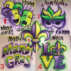 May include: A selection of airbrushed designs with Mardi Gras themes. Includes masks, fleur-de-lis, and the words "Mardi Gras" and "Love" in bright colours. Some designs include names.