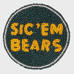 May include: Circular beaded patch with the words "SIC'EM BEARS" in yellow beads on a dark green background. The patch is bordered by a white beaded ring, creating a distinct edge. This item is likely a sports-themed accessory.