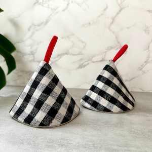 May include: Two black and white gingham pot holders with red handles. The pot holders are shaped like cones.