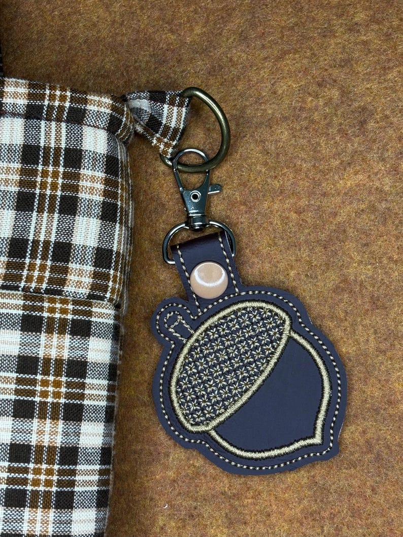 May include: A white ceramic mug with a black handle and the text "But First, Coffee" in a bold, black font. The mug is set against a blurred background, suggesting a cozy setting. The mug appears to be approximately 4 inches tall.