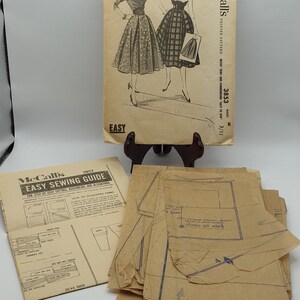 May include: A vintage McCall's sewing pattern for a skirt and cummerbund. The pattern is for sizes 24-25 and has a waist measurement of 25 inches. The pattern is printed on paper and includes instructions and diagrams. The pattern is labelled "Easy to Sew" and is from the 1950s.