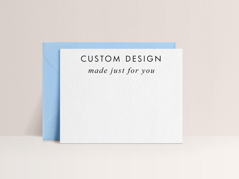 May include: A white card with the text "CUSTOM DESIGN made just for you" is propped up against a light blue envelope. The card and envelope are set against a neutral background.
