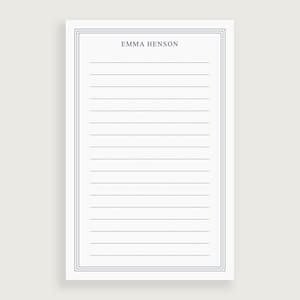 May include: A white lined notepad with a blue border and the name "Emma Henson" printed at the top.