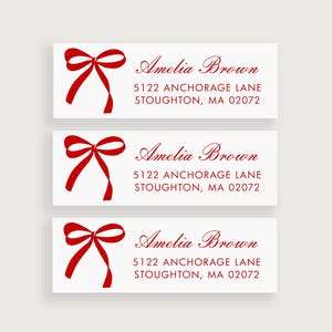 May include: Three white return address labels with a red bow and the text "Amelia Brown", "5122 Anchorage Lane", and "Stoughton, MA 02072".