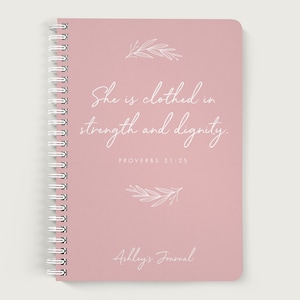 May include: A pink spiral bound journal with the quote "She is clothed in strength and dignity."  Proverbs 31:25. The journal is titled "Ashley's Journal".