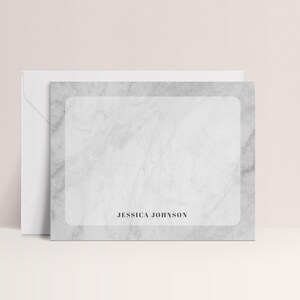 May include: A marble-patterned stationery set featuring a card and envelope. The card has a light gray marble design with a white rectangular space for writing and the name "JESSICA JOHNSON" printed in black.