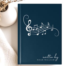 May include: A dark blue notebook with a white musical note design and the text "written by NOAH WILLIAM".