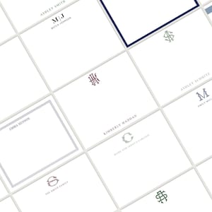May include: A collection of personalized stationery cards with various monogram designs and names. The cards are white with gray grid lines, and the monograms and names are in shades of blue, burgundy, and green. The cards are arranged in a grid pattern.