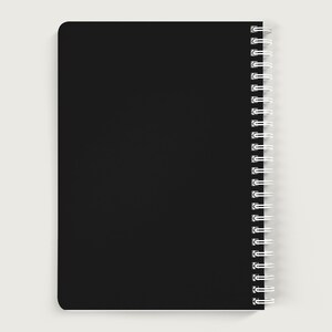 May include: A black spiral bound notebook with a blank cover.