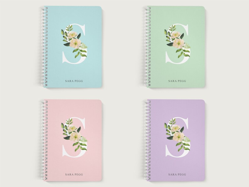 May include: Four spiral bound notebooks with floral designs and the letter "S" on the front. The notebooks are in four different colors: light blue, light green, pink, and purple. Each notebook has the name "SARA PEGG" printed on the front.