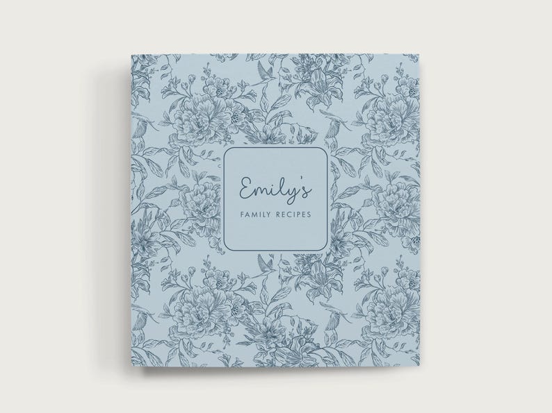 May include: A light blue recipe binder with a floral pattern. The cover features a square label with the text "Emily's Family Recipes" in a script font. The floral design includes detailed drawings of flowers and leaves.
