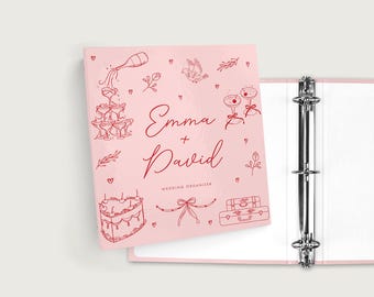 May include: A pink wedding organizer binder with red line art illustrations of champagne glasses, a cake, and luggage. The names "Emma + David" are written in cursive, with "Wedding Organizer" below.
