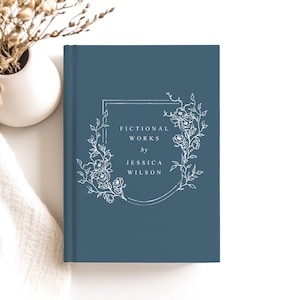 May include: A blue hardcover book with a white floral design and the text "Fictional Works by Jessica Wilson".
