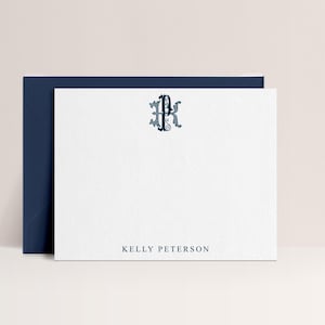May include: A white stationery card with a navy blue envelope. The card features a navy blue monogram at the top and the name "KELLY PETERSON" printed at the bottom. The stationery is suitable for personalized correspondence.