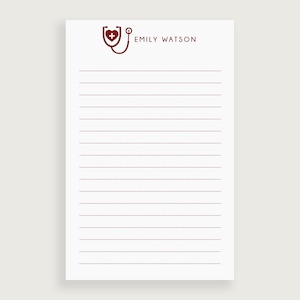 May include: A white notepad with a red stethoscope and heart logo and the text "EMILY WATSON" at the top. The notepad has red dotted lines.