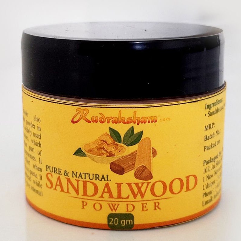 May include: A small yellow jar with a black lid containing sandalwood powder. The label reads "Pure & Natural Sandalwood Powder 20 gm" and features a small bowl of sandalwood powder and a piece of sandalwood wood.