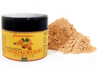 May include: A small jar of sandalwood powder, labeled "Pure & Natural Sandalwood Powder 20 gm" with a yellow label and a black lid. The jar is sitting on a white surface next to a pile of the powder.