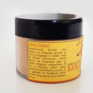 May include: A yellow and brown jar of sandalwood powder with the text "About Product" and "Sandalwood Powder" on the label. The label also includes information about the product's use in Hindu ceremonies and its cooling effect.