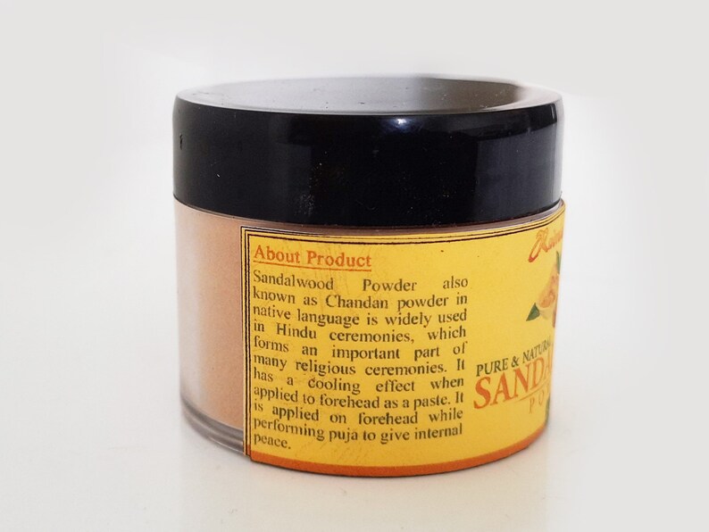 May include: A yellow and brown jar of sandalwood powder with the text "About Product" and "Sandalwood Powder" on the label. The label also includes information about the product's use in Hindu ceremonies and its cooling effect.