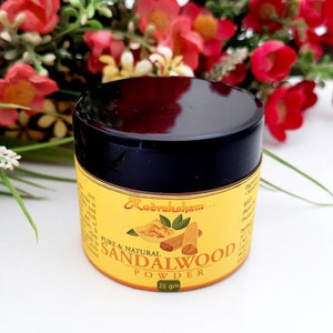May include: A small, round jar of sandalwood powder with a black lid. The jar is labeled "Pure & Natural Sandalwood Powder" and "25 gm".