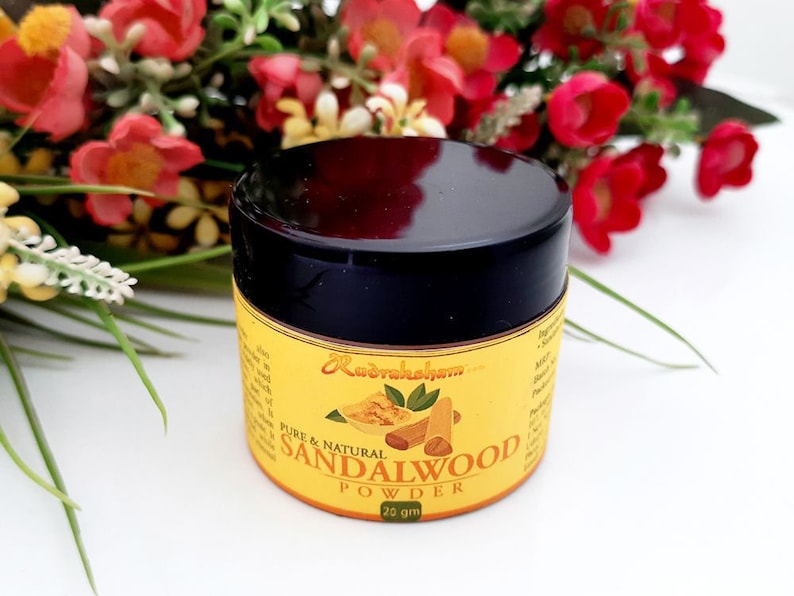 May include: A small, round jar of sandalwood powder with a black lid. The jar is labeled "Pure & Natural Sandalwood Powder" and "25 gm".