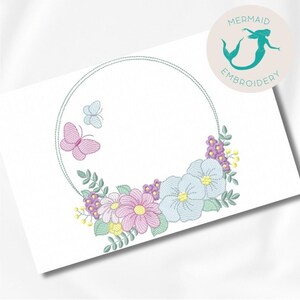 Peut inclure: Un motif de broderie circulaire avec une couronne de fleurs pastel et de papillons. La couronne est entourée d'un cercle de points de couture.