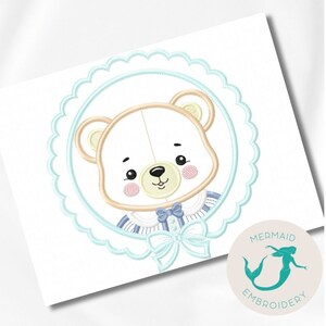 May include: Embroidered design of a cute bear wearing a blue and white striped shirt with a bow tie, inside a blue scalloped circle. The design is perfect for baby clothes, blankets, or other crafts.