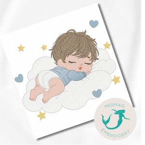 May include: An embroidered design of a sleeping baby boy on a cloud, with stars and hearts. The baby wears a blue shirt and a nappy. The design is on a white background, with a mermaid logo in the corner.