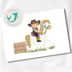 May include: Embroidered design of a cowboy riding a white horse with a brown fence in the background. The cowboy is wearing a brown hat with a star, a red bandana, and blue jeans. The horse has a brown mane and tail.