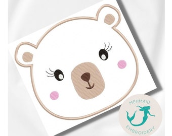 May include: Embroidered design of a white bear face with brown nose and eyes, pink cheeks, and eyelashes. The design is on a white background.
