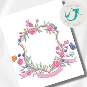 May include: A pink and green floral embroidery design with a brown frame and a pink ribbon. The design includes butterflies and flowers.