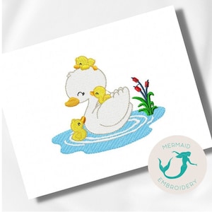 May include: Embroidered design of a white duck with three yellow ducklings in a blue pond. The ducklings are on the duck's back and in the water. There are green reeds and red flowers in the background.