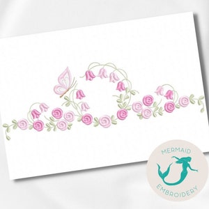 May include: Embroidered design featuring a pink butterfly, pink roses, and pink bell flowers. The design is perfect for a border or a decorative element on a fabric project.
