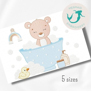 Puede incluir: Un oso de peluche marrón en una bañera azul con burbujas de espuma blancas. Un pato de goma amarillo está en primer plano. Un arcoíris y una botella de jabón también están incluidos en el diseño.