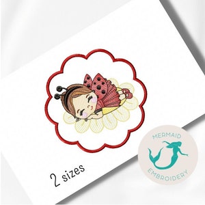 Peut inclure: Broderie d'une petite fille coccinelle endormie sur une fleur. Le motif est dans un cercle rouge avec un bord festonné. Le texte "2 tailles" est sous le motif.