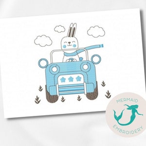 Pode incluir: Desenho bordado de um coelho branco com uma echarpe azul dirigindo um jipe azul com três estrelas na frente. O coelho está sorrindo e tem um volante azul. O jipe está em uma estrada de terra marrom com grama verde de cada lado. O desenho é cercado por nuvens brancas.