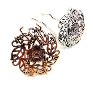 Pu&ograve; includere: Due fermagli per capelli con un design floreale. Un fermaglio &egrave; dorato e l'altro &egrave; argentato. Il design floreale presenta un fiore con foglie.